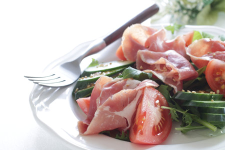 Homemade tomato and ham salad with leaf vegetableの写真素材