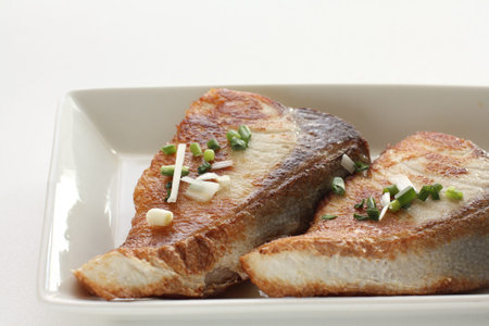 Chinese food, pan fried yellowtail fillet with spring onion on top