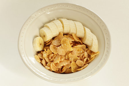 Chopped banana and corn flake in bowl with copy space