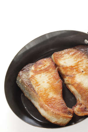 Chinese food, pan fried yellow tail fish fillet in cooking panの写真素材