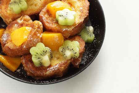 Homemade kiwi fruit and mango with honey on French toastの写真素材