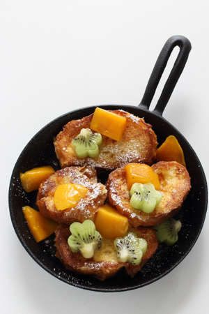 Homemade kiwi fruit and mango with honey on French toastの写真素材