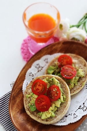 Avocado paste and cherry tomato in English muffin sandwich