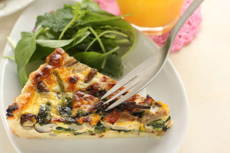 Homemade a piece of mushroom and spinach with bacon quicheの写真素材