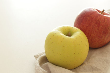 Red and yellow apples in a linen cloth on a white background.の写真素材