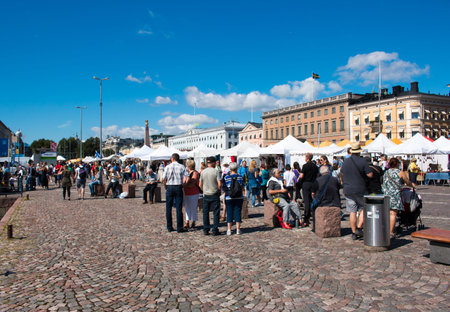 Tourists and locals shopping and sightseeing in Market Square, Central Helsinki, sunny weatherのeditorial素材
