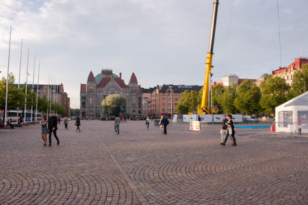 Helsinki Railway Square during dusk, tourists and local people walking around the square, sunny weather with light cloudsのeditorial素材