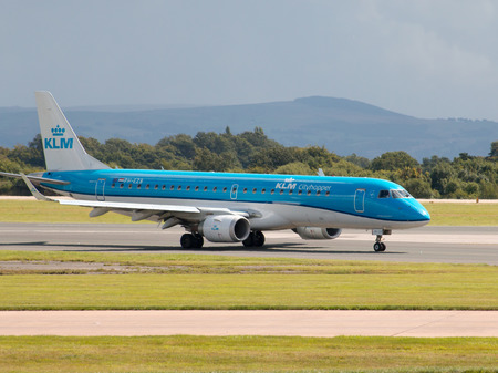 KLM Cityhopper Embraer ERJ-190 PH-EZB passenger plane taxiing on Manchester International Airport runway.のeditorial素材