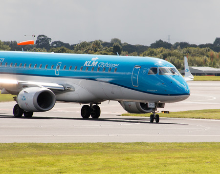 KLM Cityhopper Embraer ERJ-190 PH-EZB passenger plane taxiing on Manchester International Airport runway.のeditorial素材