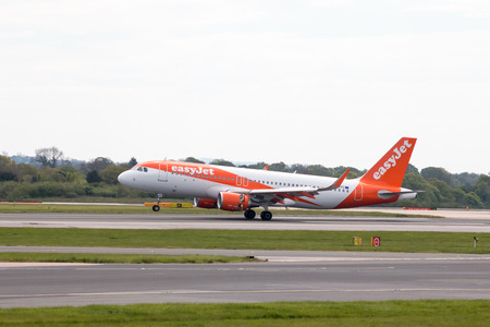 easyJet A320-214 narrow-body passenger plane (G-EZPC, in Europcar Livery) landing to Manchester International Airport runway.のeditorial素材