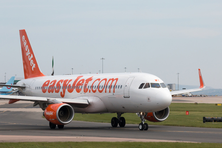 easyJet A320-214 narrow-body passenger plane (G-EZWZ) taxiing on Manchester International Airport tarmac.のeditorial素材