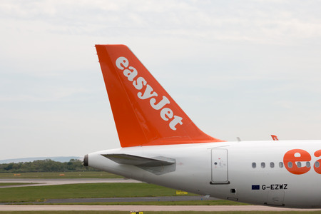 Vertical stabilizer of easyJet A320-214 narrow-body passenger plane (G-EZWZ), Manchester International Airport tarmac.のeditorial素材