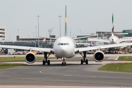 Thomas Cook Airlines Airbus A330-243 wide-body passenger plance (G-TCXC) taxiing on Manchester International Airport tarmac.のeditorial素材
