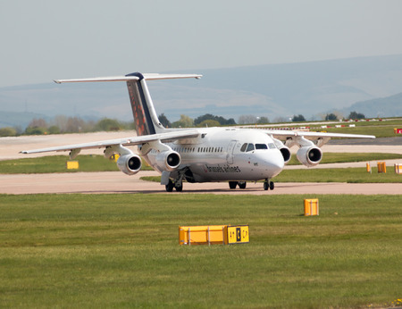 Brussels Airlines Avro RJ-100 short-haul regional passenger plane (OO-DWE) taxiing on Manchester International Airport tarmac.のeditorial素材