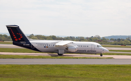 Brussels Airlines Avro RJ-100 short-haul regional passenger plane (OO-DWE) taxiing on Manchester International Airport tarmac.のeditorial素材