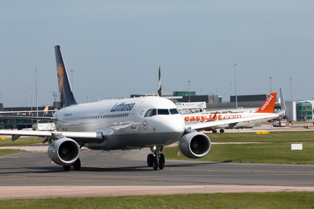 Lufthansa A319-100 narrow-body passenger plane (D-AIZY) taxiing on Manchester International Airport tarmac.のeditorial素材