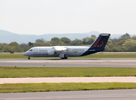 Brussels Airlines Avro RJ-100 short-haul regional passenger plane (OO-DWE) taxiing on Manchester International Airport tarmac.のeditorial素材