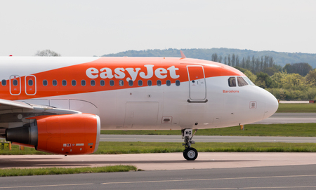 easyJet A320-214 narrow-body passenger taxiing on Manchester International Airport tarmac.のeditorial素材
