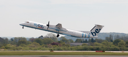 Flybe Bombardier Dash 8 Q400 twin-engine, medium range, turboprop passenger plane (G-JECP) taking off from Manchester International Airport runway.のeditorial素材