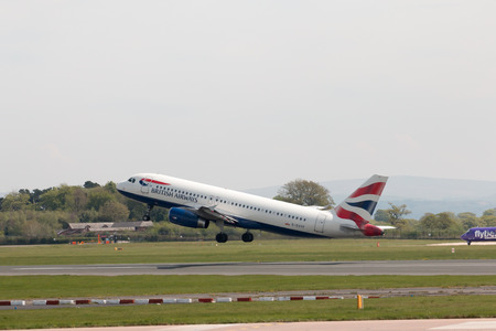 British Airways Airbus A320-232 narrow-body passenger plane (G-EUYF) taking off from Manchester International Airport runway.のeditorial素材