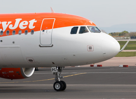 easyJet A320-214 narrow-body passenger plane (G-EZPC) taxiing on Manchester International Airport tarmac.のeditorial素材