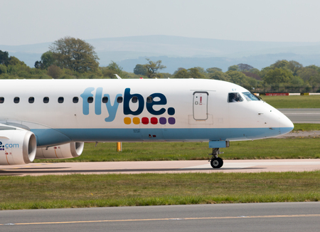 Flybe Embraer ERJ-195LR narrow-body medium-range twin-engine jet airliner (G-FBEF) taxiing on Manchester International Airport tarmac.のeditorial素材