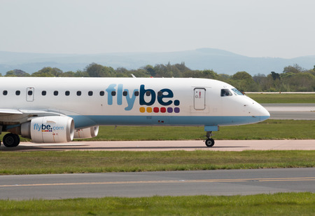 Flybe Embraer ERJ-195LR narrow-body medium-range twin-engine jet airliner (G-FBEF) taxiing on Manchester International Airport tarmac.のeditorial素材