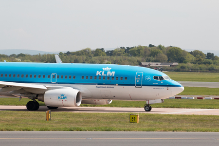 KLM Boeing 737-7K2 narrow-body passenger plane (PH-BGR) taxiing on Manchester International Airport tarmac.のeditorial素材