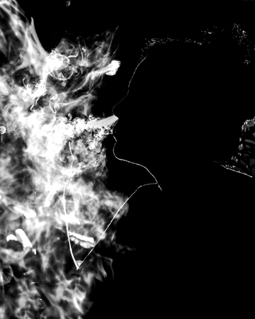 A woman silhouette surround by cigar smoke getting out from her nose.の写真素材