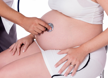 Pregnant woman being attended by a doctorの写真素材