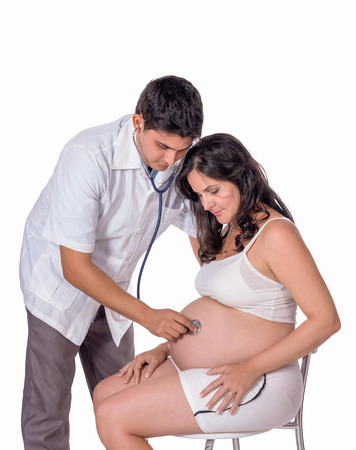 Pregnant woman being attended by a doctorの写真素材