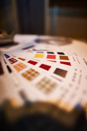 Grid of different colored fabrics on a wooden tableの写真素材