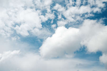 White, puffy clouds agains a blue skyの写真素材