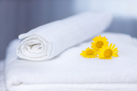 Three yellow flowers on folded towels and backlightの写真素材