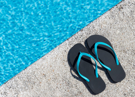 Close-up of a pair of flip-flops on the edge of a pool. Copy space. Top view.の写真素材