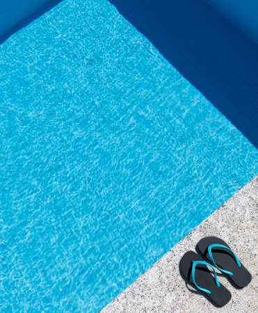 Flip flops on the edge of a pool. Copy space. Top view.の写真素材