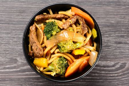 black bowl with yakisoba on a dark tableの写真素材