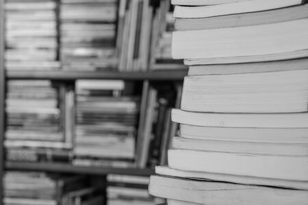 books on the table and in bookshelves in the backgroundの写真素材