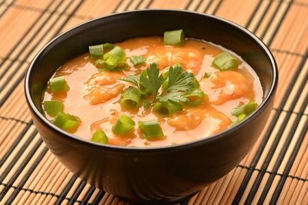 shrimp moqueca with chives, parsley and pepper.の写真素材
