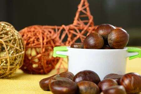 portuguese nuts in ceramic container over yellow jute and with Christmas ornamentsの写真素材