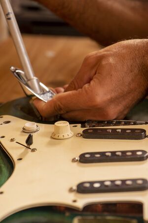 luthier working on repairing a guitarの写真素材