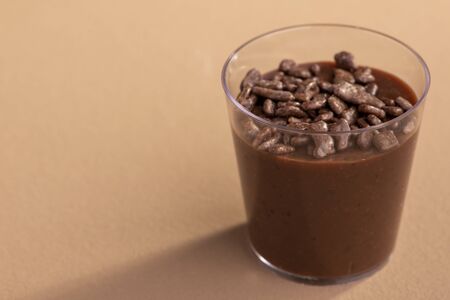 acrylic cup with brigadeiro and chocolate sprinkles on brown background.の写真素材