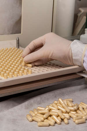 pharmacy professional using encapsulating plate for the production of homeopathic or allopathic remedies.の写真素材