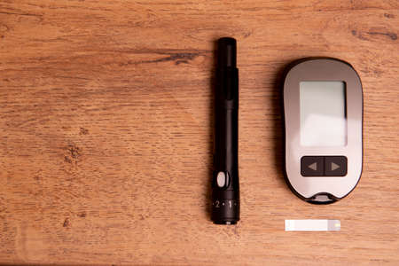equipment for measuring blood glucose on wooden table.の写真素材