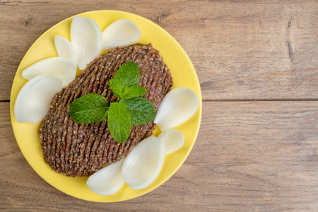raw kibe with sliced onion and a sprig of mint.の写真素材