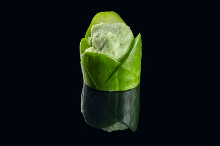 Portion of wasabi inside piece of cucumber on black background.の写真素材