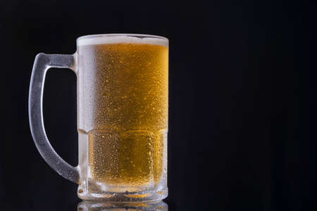 a mug of cold beer on black background.の写真素材
