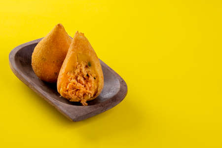 Fried drumstick in wooden container on yellow background.の写真素材