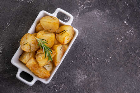 bowl of rustic fried and roasted potatoes with rosemary.の写真素材