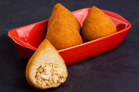 Traditional fried coxinha stuffed with chicken and a glass of cold soda.の写真素材
